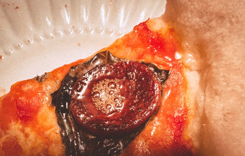 Close up of a pepperoni on a pizza slice