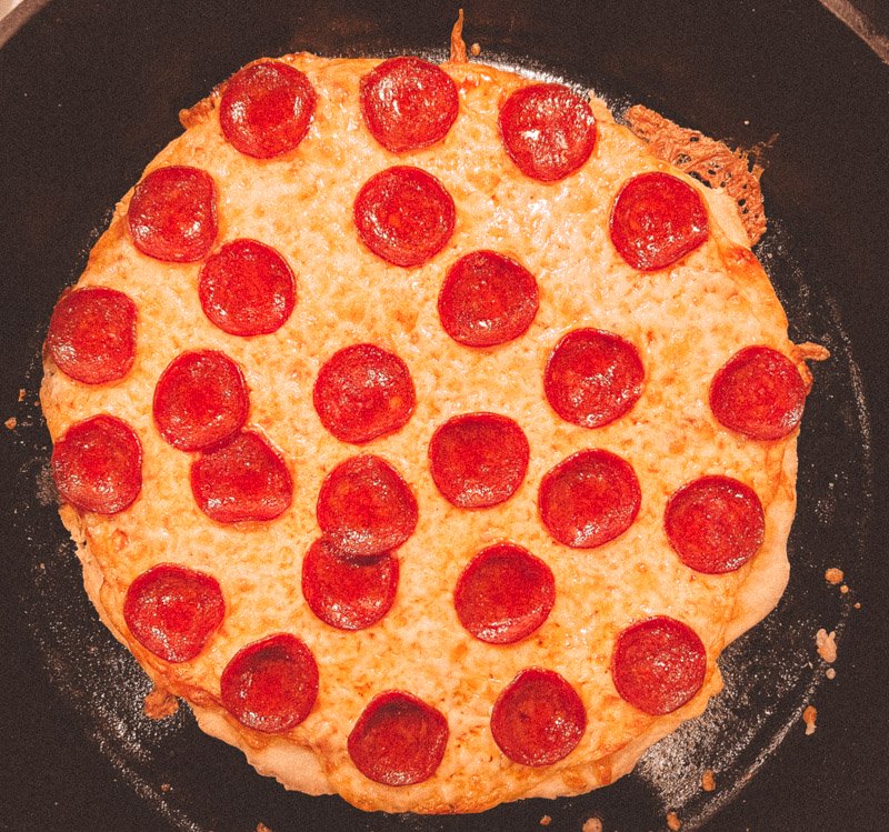 Overhead shot of an unsliced St. Louis style pizza. 