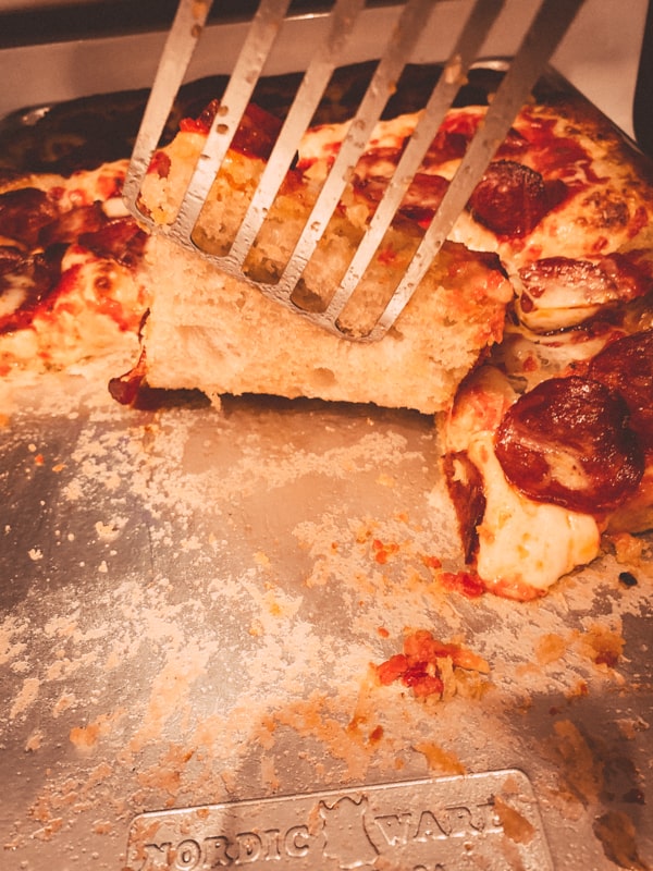 Pale underside of pizza crust. 