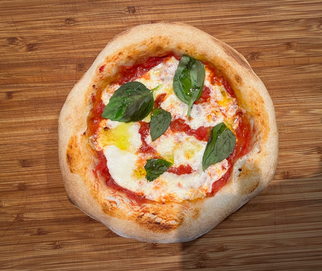 Pizza from overhead with basil, olive oil, and fresh mozzarella. 